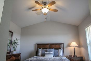 The master bedroom has a ceiling fan and a large bed